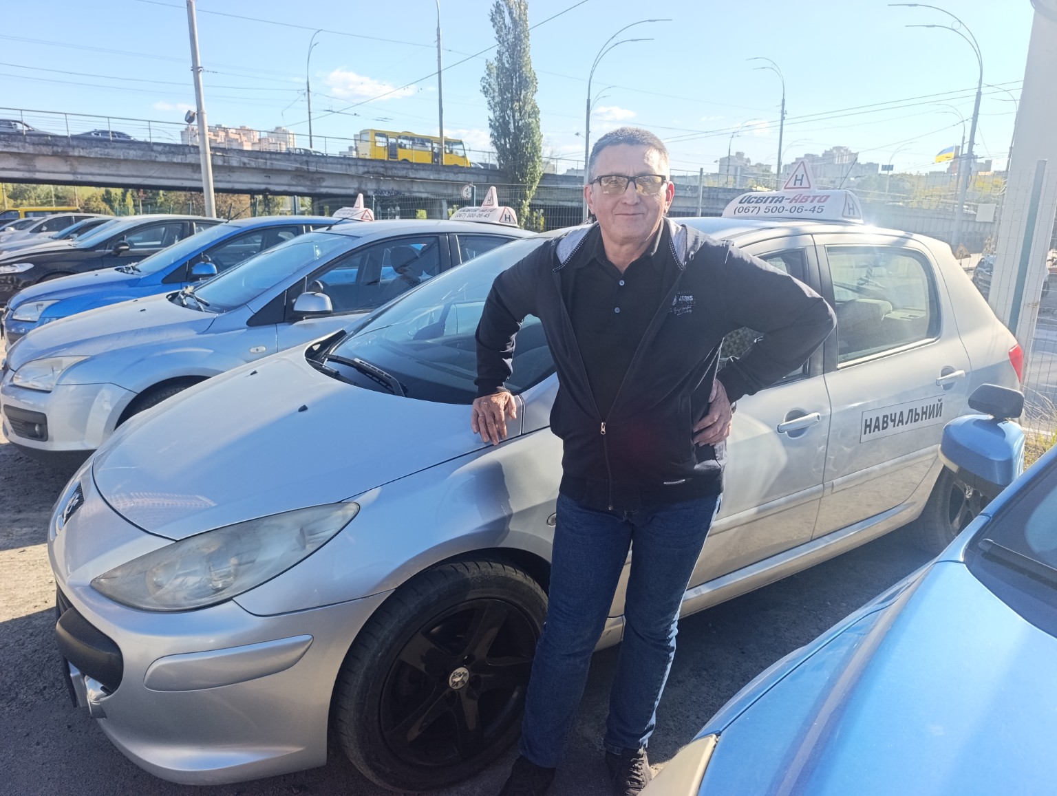 Інструктор автошколи Кулагін Роман Валерійович біля навчального автомобіля Peugeot